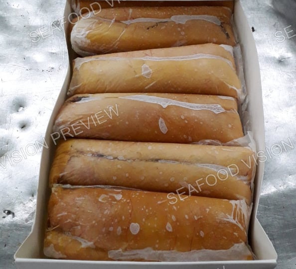 Frozen golden-brown fish blocks stacked in an open carton